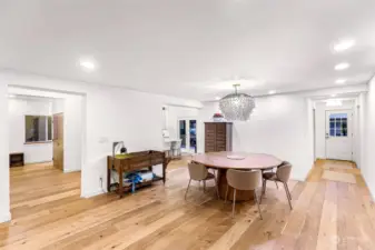 From the dining area, enjoy a seamless connection to the living and kitchen spaces, enhanced by wide-plank floors and a stylish chandelier. Perfect for gatherings and daily life.