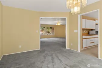 Dining roof facing living room with kitchen entry.
