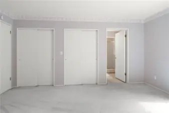 Primary Bedroom facing 2 of 4 closet spaces and bathroom entry. Entry door is on the left.