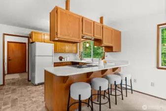 An extended countertop in the kitchen provides extra seating for casual dining or conversation.