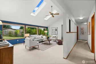 Featuring a half-wall that divides the living room from the wide hallway, this design maintains openness while subtly defining spaces.