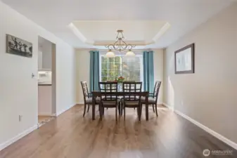 Just adjacent to the living room is a dedicated dining area with trayed ceilings.