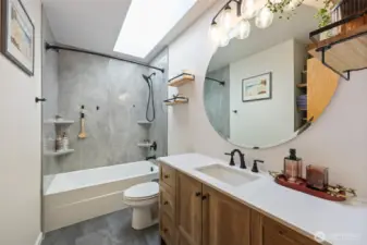 Full hall bath. Durabath slab in shower as well. Skylight brings in a ton of light. Storage shelf behind door.