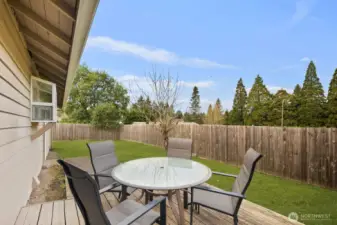 Inviting backyard retreat with a patio perfect for outdoor dining, a level grassy lawn, and full fencing for privacy