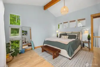 Primary bedroom on the upper-level, enjoys tall, vaulted ceiling and large windows.