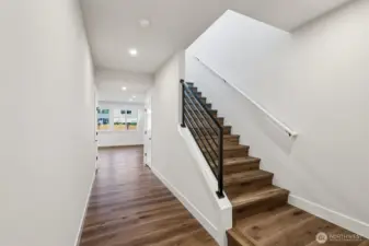 Stairs to second floor featuring a metal railing.