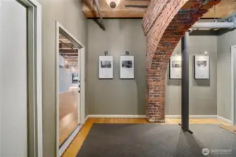 Foyer of floor 3. Unifying artwork. Original fir floors and exposed brick.