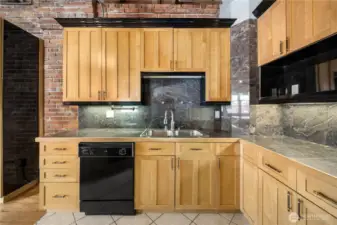 Under counter lighting, stainless steel sink, and granite counters and backsplash.