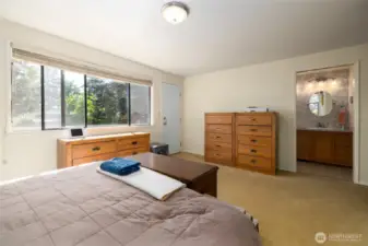 Primary bedroom looks out toward the garden and deck.