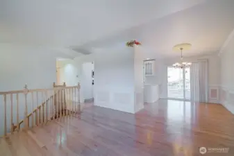 Living room/dining room with custom wainscoting and vaulted ceilings.