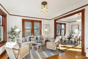 The living room features high ceilings and original millwork.  High-end Anderson windows have been added.