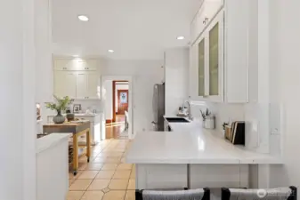 The kitchen has a sweet eat-in counter with room behind for additional seating.  The Shaker cabinets extend all the way to the ceiling for maximum storage.