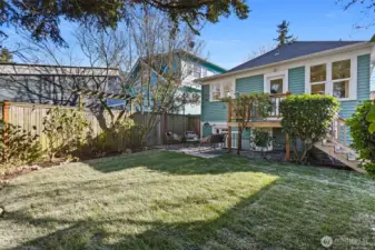 The backyard sanctuary is so private and features a patio and lawn surrounded by mature plantings.