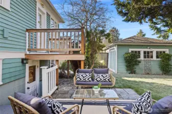 Patio looking toward the 1 car detached garage.  Here you may also see the separate entry into the lower level of the home.