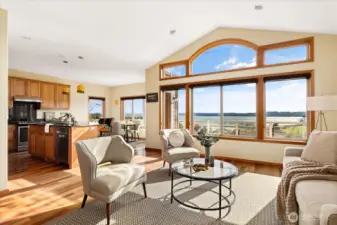 The grand living room includes vaulted ceilings that allow for large view windows to soak up the sun and take in the water views.