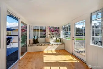 Just off the living room is this absolutely charming sunroom with built in seating that transitions seamlessly to a small bistro area to the right or to the large entertainment-sized deck In the back yard.