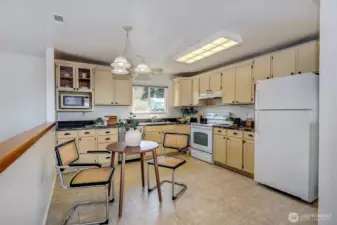 This roomy kitchen offers an efficient layout with plenty of cabinetry and counter space. The sunny eating area provides a perfect spot for casual meals.