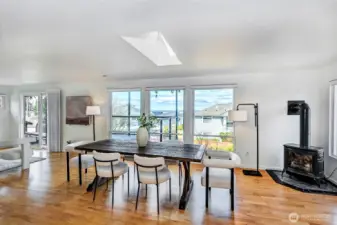 Extra-large dining room centered around a cozy gas stove and bathed in natural light from a venting skylight. Perfect setting for large gatherings with a warm, inviting atmosphere.