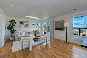 This spacious living room is bathed in natural light, offering a seamless flow between kitchen and outdoor space.