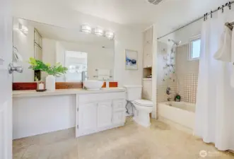 Function meets style in the primary bath, which includes a convenient built-in linen tower and a spacious vanity.