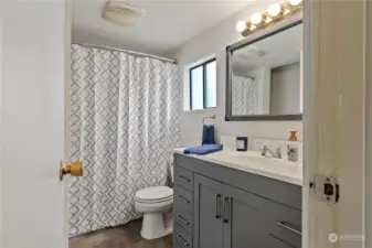 The bathroom has new flooring, vanity, and mirror.