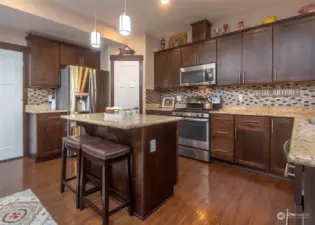Rich colors, granite slab counter tops and eat in kitchen.