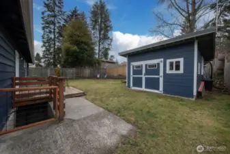 Backyard is fully fenced, has a large outbuilding (metal roof, double pane windows, concrete slab - finish it for a killer office or studio?) sunny patio and lots of space for play.