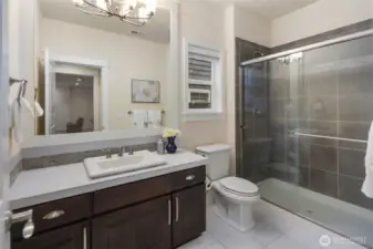 Main level three-quarter bath, tile floor and tile shower surround.