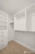 A custom walk-in closet with built-in shelving and hanging storage makes staying organized a breeze in the primary suite.