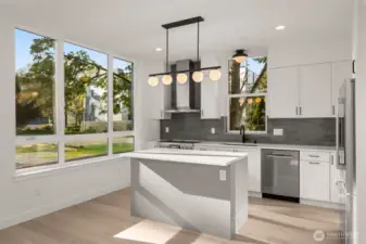 Sleek finishes and clean lines define this designer kitchen—complete with SS appliances, quartz counters, and plenty of prep space.