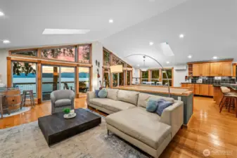 Wide-open great room for gathering. Vaulted Ceilings and walls of windows rising toward the sky