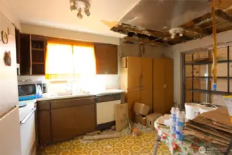 Entering into the kitchen from the living room. The ceiling sheetrock has gone to that Great Home Depot in the sky...