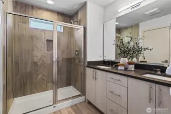 Primary bath boasts oversized shower plus dual vanities with quartz counters and undermount sinks