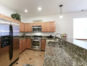 Granite counter tops. Stainless double sink. Upgraded Faucet. All appliances Stainless stay with home. Gas Stove. Pull out drawers. Tile Flooring in Kitchen.