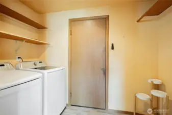 Utility room with room for a deep freezer, folding table or mud-room area off the garage.
