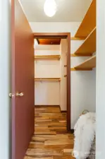 Large walk-in primary closet with built-in storage nook.
