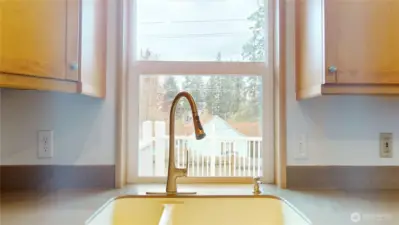 The kitchen sink overlooks the expansive back deck and yard.