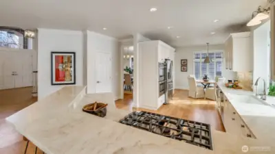 Kitchen features expansive countertops and both a casual seating and counter seating. Door on the left is a large walk-in pantry.