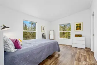 The spacious primary bedroom is filled with natural light and features a walk-in closet and a private ensuite bath.