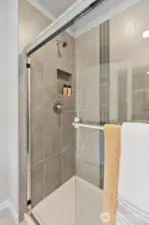 Glass surround on your walk in shower, separate from your free standing soaking tub. Photo rendering is representational. Actual home is under construction and finishes, elevation, and paint colors may vary. See site agent for details.