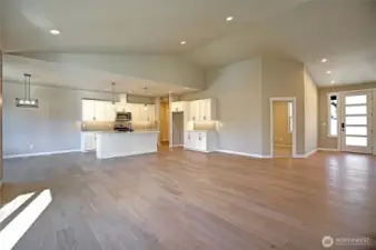 Open kitchen with a large Island, tile back splash, stainless appliances, soft close drawers and cabinets and undercounter accent lighting.