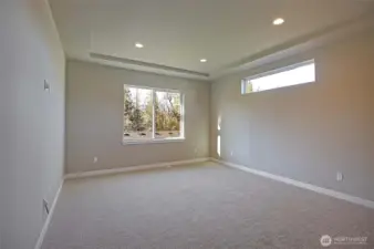 Primary bedroom has a coffered ceiling and lots of light.