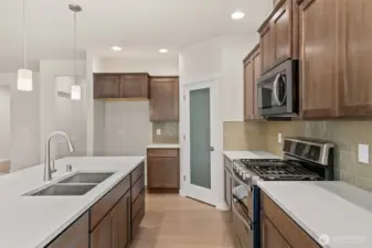 Great workspace and flow through the kitchen. Stainless steel Whirlpool multi-cycle dishwasher,  microwave hood and double oven are all standard!