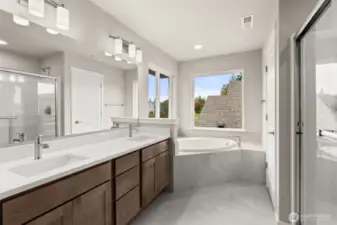 Five-piece primary bath features tile flooring with full tiled tub deck for the soaking tub, walk-in shower and dual vanity.