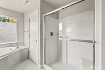 Primary bathroom includes a private water room and standing shower with clear glass doors.