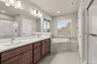 Five-piece primary bath features tile flooring with full tiled tub deck for the soaking tub, walk-in shower and dual vanity.