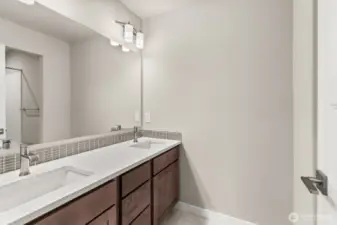 Upstairs hall bath features a dual vanity with quartz counters and backsplash.