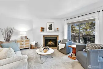 Main living area with tiled wood fireplace and mantle, new Karastan carpet and fresh paint. Lovely natural light comes through the wall of windows.