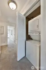 Utility closet with stacked washer and dryer.