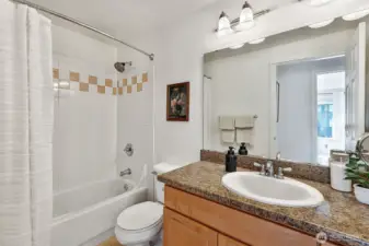 Full bathroom with tub-shower combo, granite counters, new paint and tile floors. Additional linen closet in the hallway.